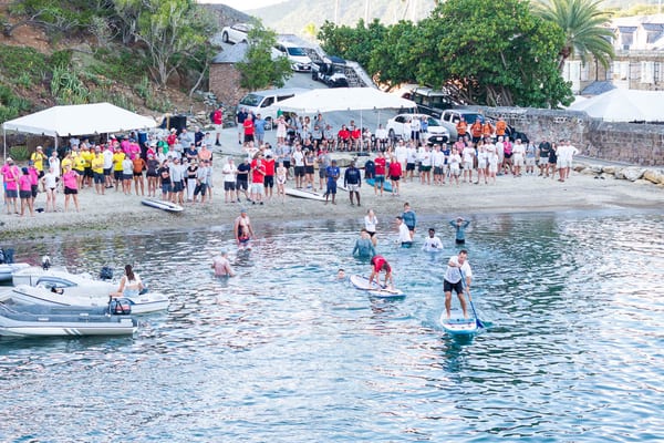 Crews and spectators gathered on the beach and in the water for a charity paddleboard race at the 2025 Antigua Superyacht Challenge.