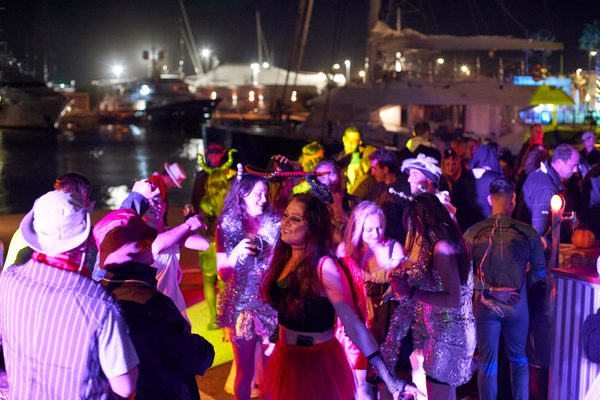 Halloween party at Pendennis Vilanova with staff and yacht crew in costume dancing by the marina at night.