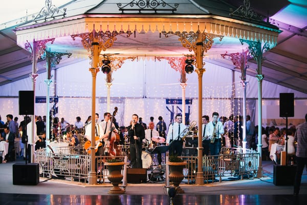 Live band performing under a decorated bandstand at the Pendennis Cup party in Falmouth's Princess Pavilions.