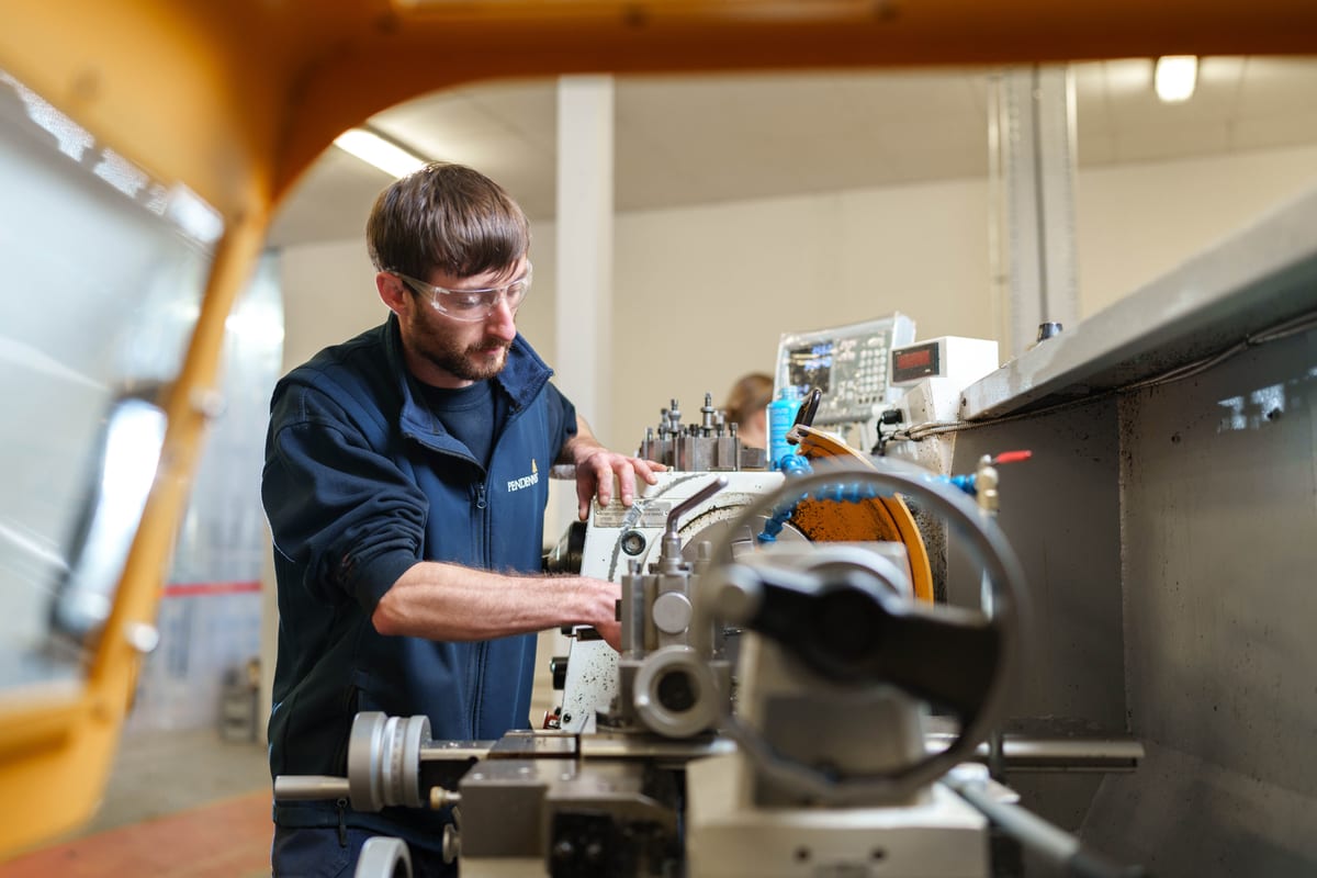 Engineer operating lathe machine at Pendennis's Digital Manufacturing Centre in Falmouth.