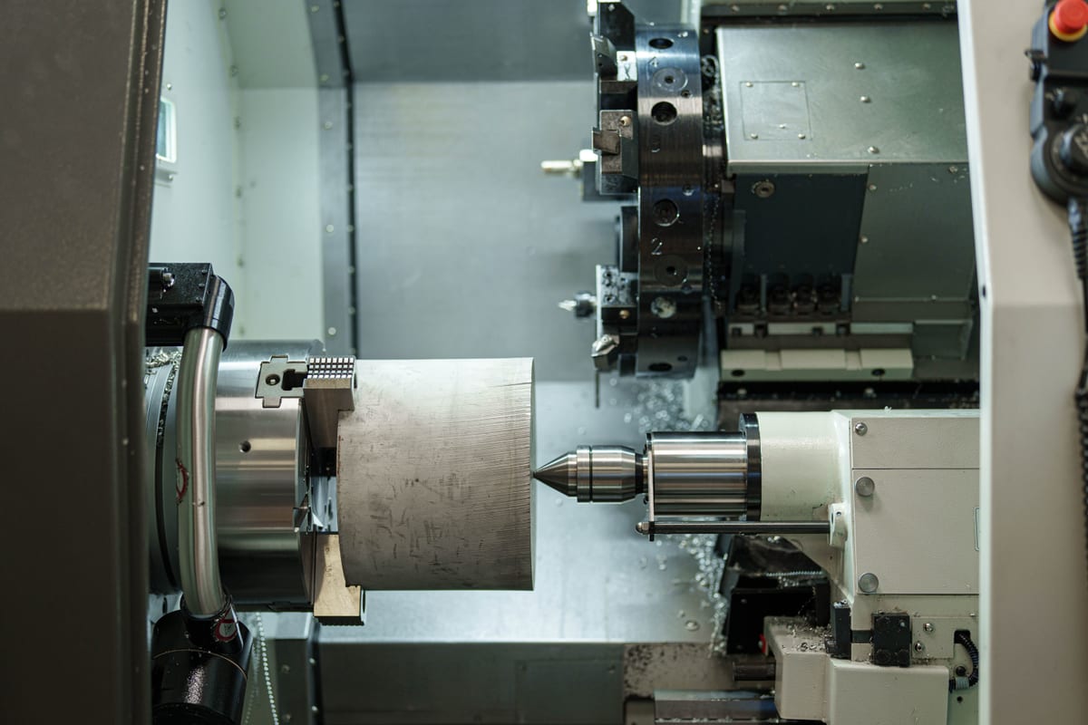 Close-up of CNC lathe machining a metal cylinder at Pendennis’s Digital Manufacturing Centre.