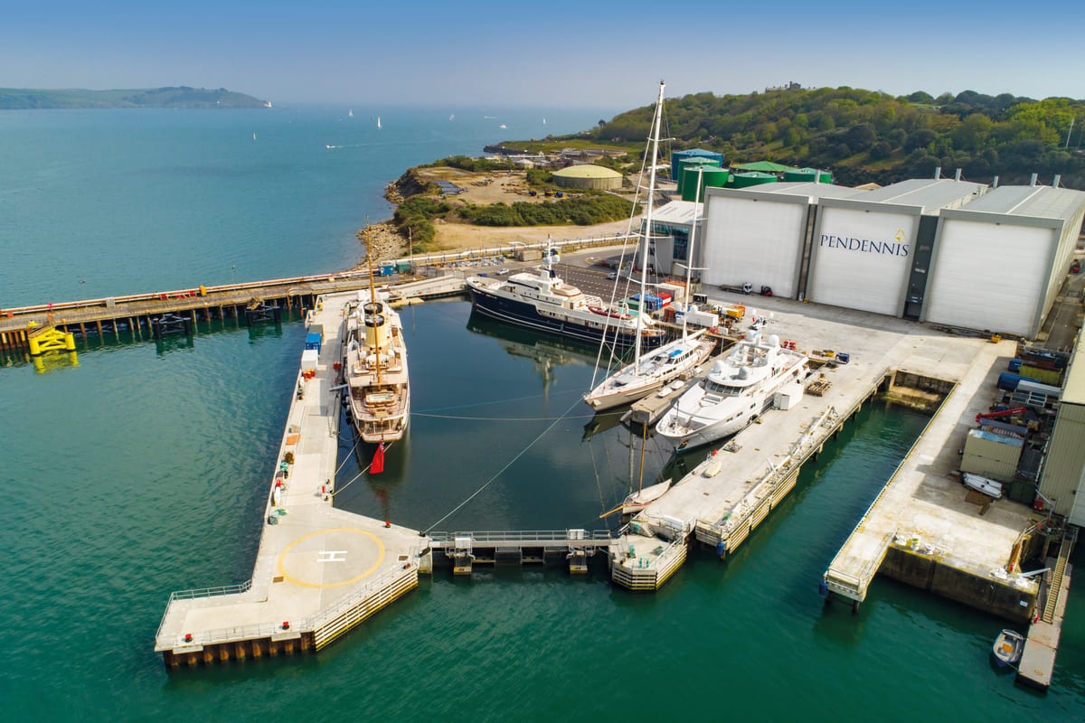 Aerial view of Pendennis' non-tidal wet basin with multiple superyachts docked alongside the shipyard facilities.