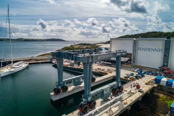 Close-up aerial of Pendennis Shipyard’s 800-tonne travel hoist beside yachts and the main facility buildings in Falmouth.