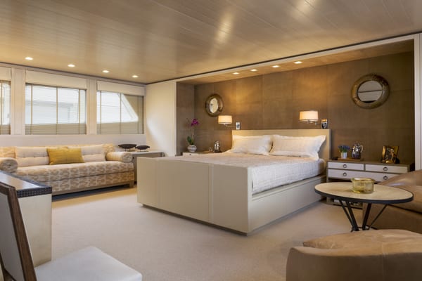 Master suite on board superyacht A2, featuring a king-size bed, soft neutral furnishings, and contemporary design with built-in lighting and panoramic windows.