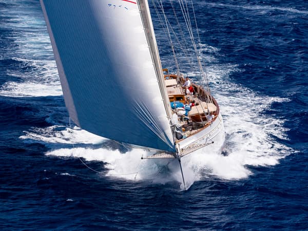 Sailing yacht Adela cutting through the waves off the coast of St Kitts, captured during her post-restoration performance following work by Pendennis.
