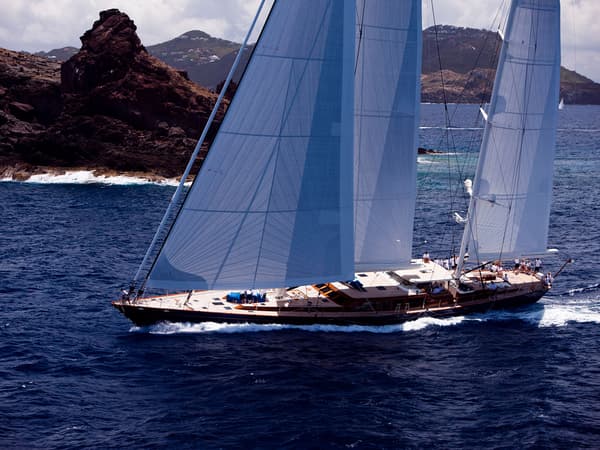 Christopher sailing past rugged coastlines with its sails up, cutting through the blue water on a sunny day at the St Barths Bucket in 2011.
