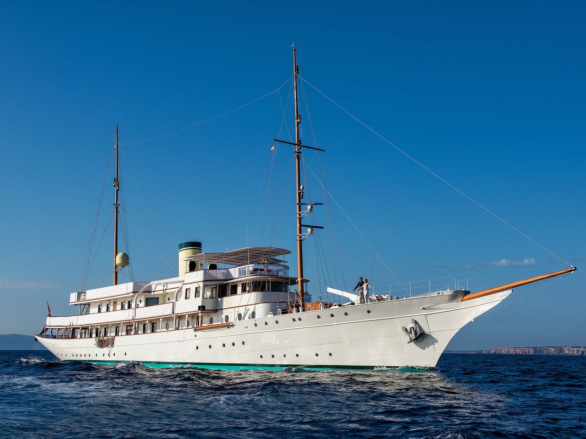 Classic superyacht Haida 1929 cruising at sea after restoration, under clear blue skies.