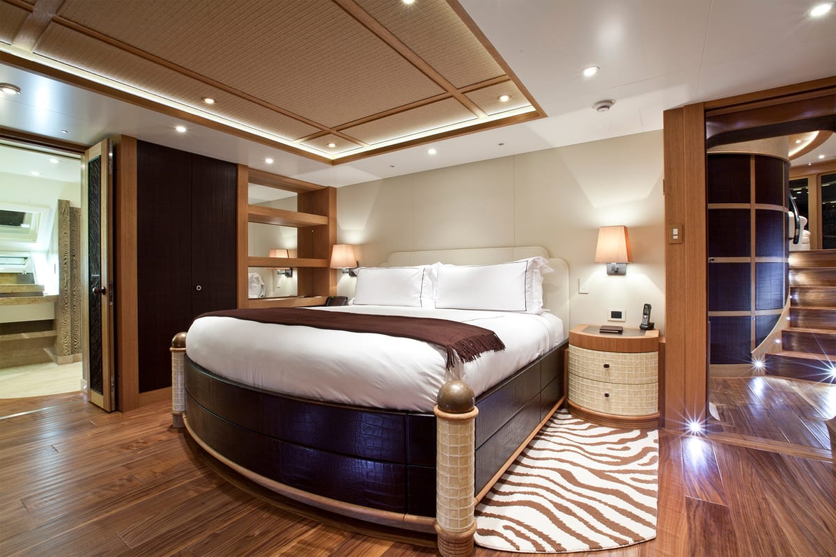 Hemisphere’s master cabin featuring a rounded bed, warm wood finishes, and soft ambient lighting.