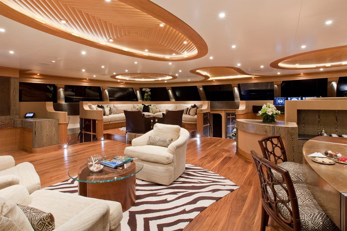 Hemisphere’s main salon with lounge seating, nav station, and custom ceiling detail in a warm wood finish.