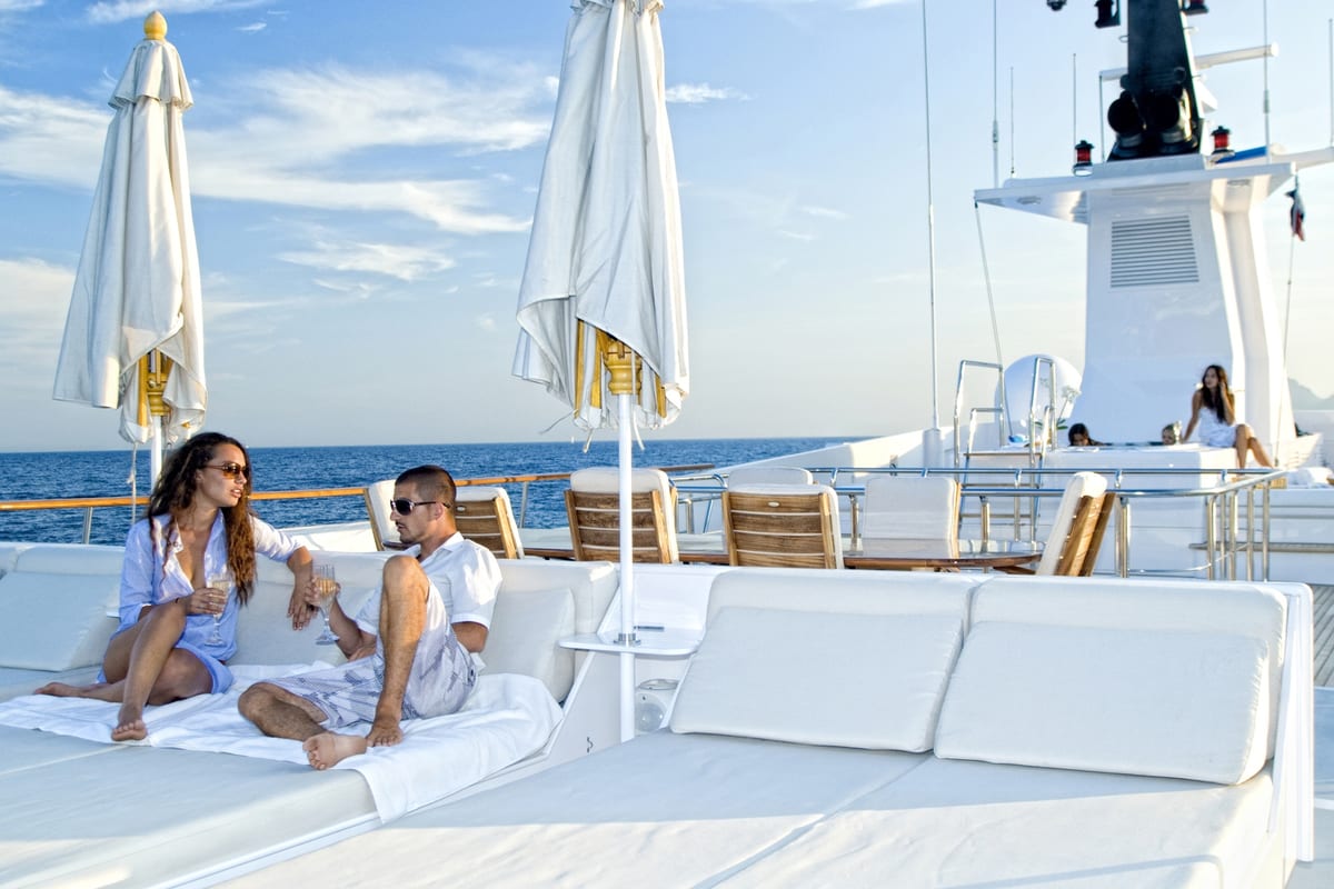 Guests relaxing on Illusion’s expanded deck space, enhanced during the Pendennis refit.
