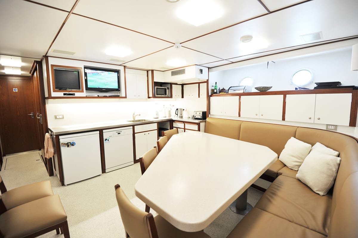 Refitted crew mess on Illusion with upgraded seating, appliances, and entertainment systems.