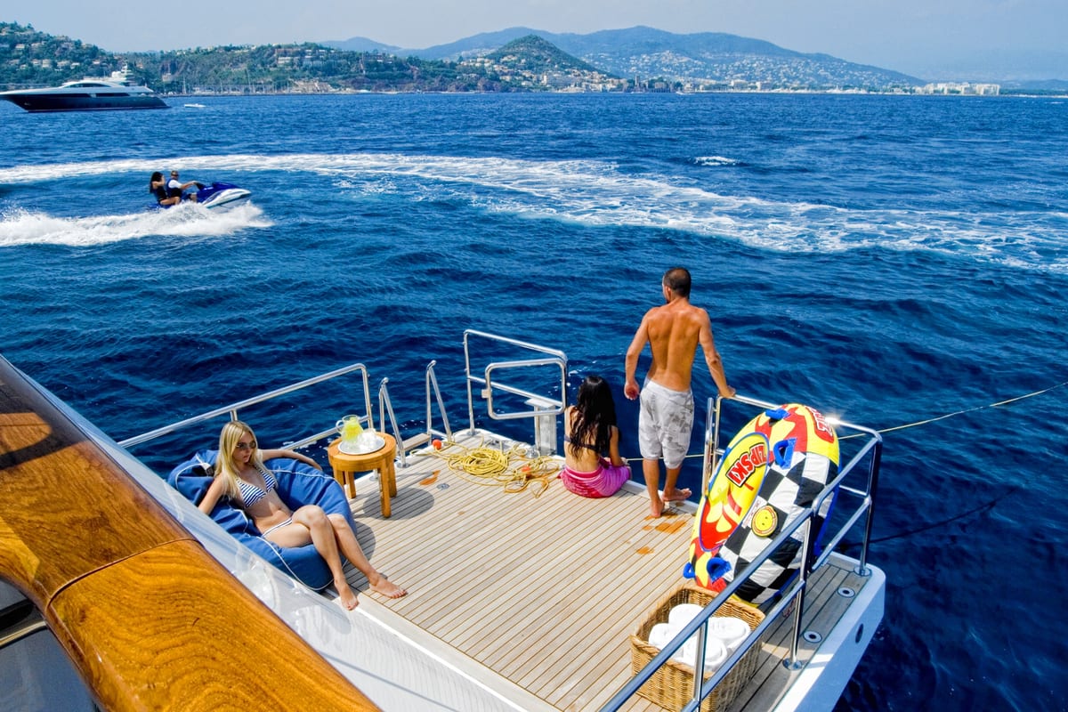 Guests relaxing and preparing watersports activities on Illusion’s extended aft swim platform.