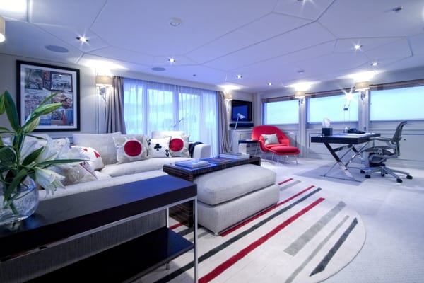 Stylish upper salon on Illusion with modern lounge area, bold accents and a private study desk.