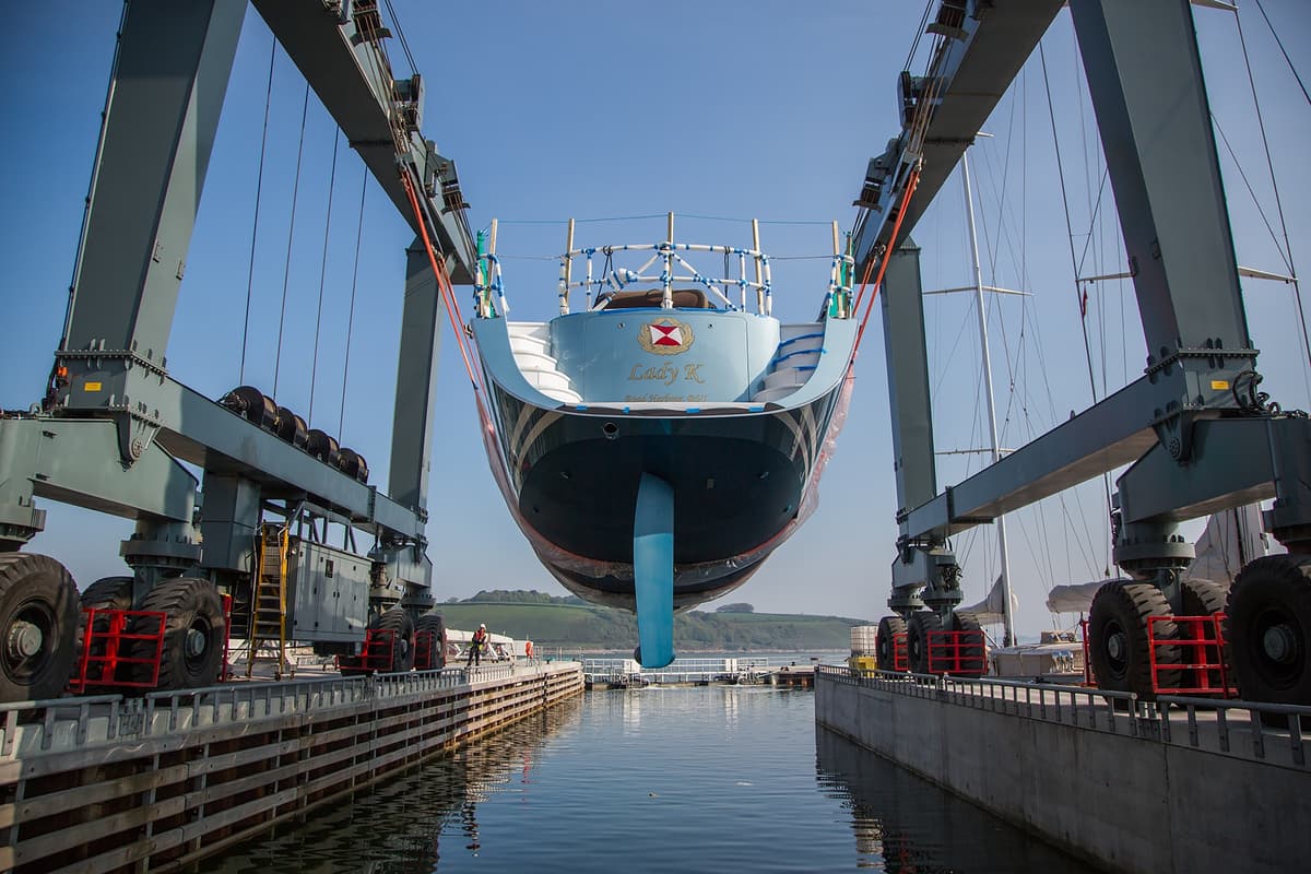 Lady K suspended in Pendennis’s travel hoist, preparing for relaunch into the wet basin.