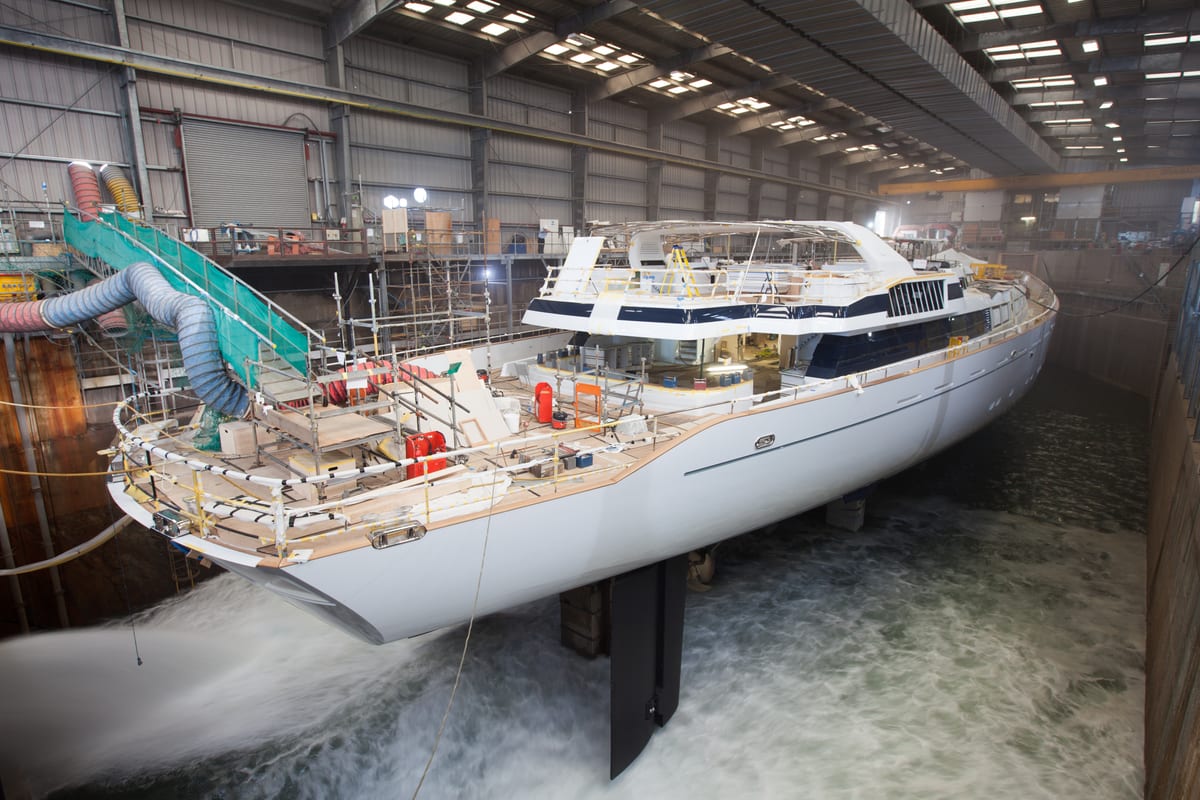 Superyacht M5 in Pendennis’ dry dock during flood-up stage of her 2013 refit, with scaffolding and equipment on deck.