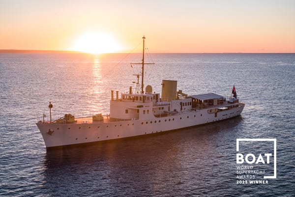 Superyacht Marala at sunset after her Pendennis restoration, with BOAT International 2023 World Superyacht Award winner badge.