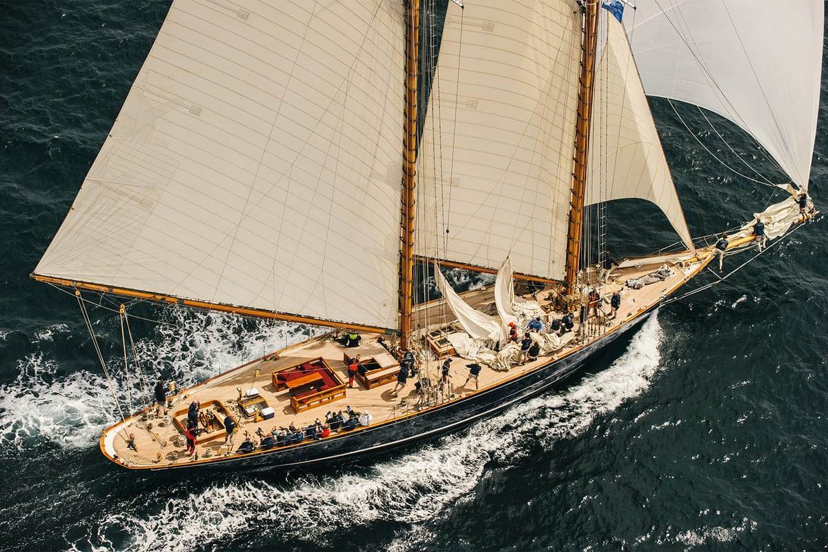 Aerial view of Mariette racing under full sail during the 2014 Pendennis Cup with crew active on deck.