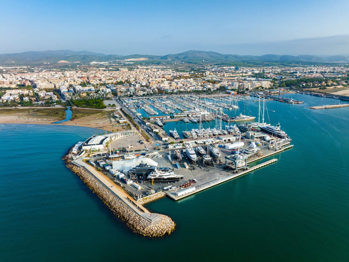Aerial view of Pendennis Vilanova marina and shipyard on a bright day, with yachts berthed along multiple piers.
