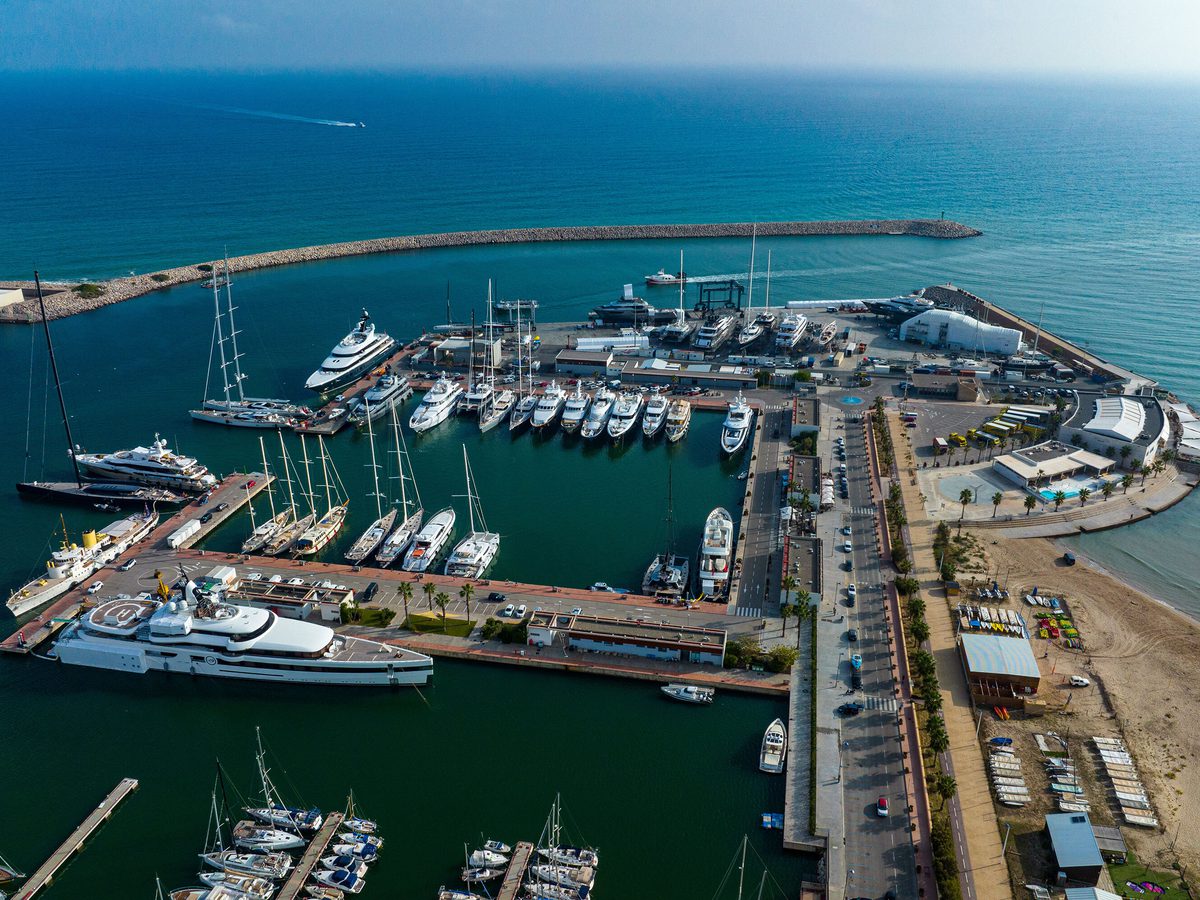 Aerial view of Pendennis Vilanova marina and shipyard on a bright day, with yachts berthed along multiple piers.