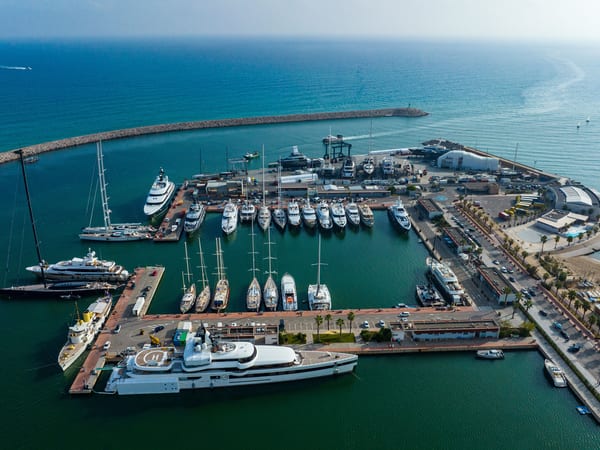 Aerial view of Pendennis Vilanova marina and shipyard on a bright day, with yachts berthed along multiple piers.