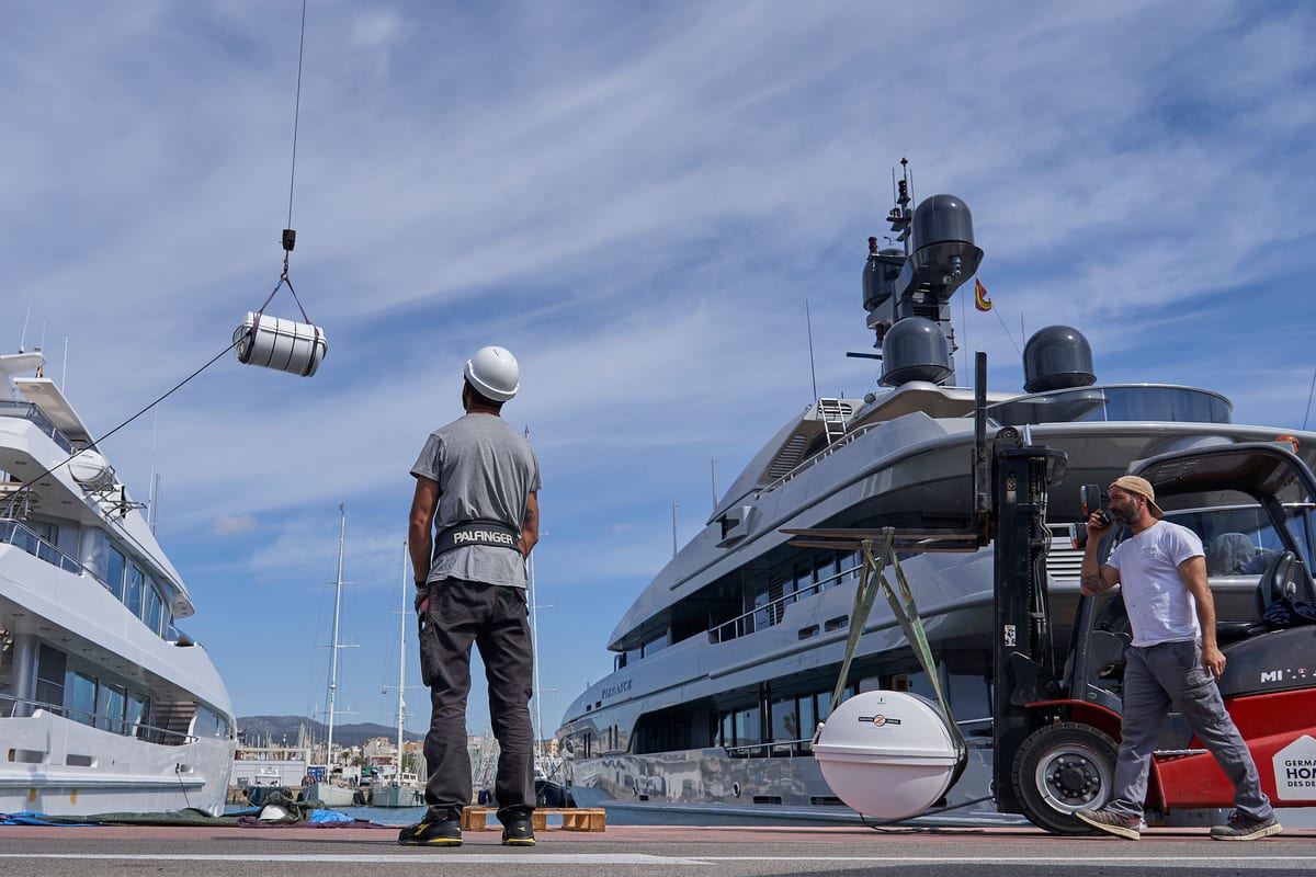 Crane truck delivering equipment to a superyacht moored at Pendennis Vilanova marina near Barcelona.